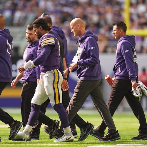 Minnesota Vikings quarterback Kyler Murray, center, walks off the field with staff after suffering an unknown injury during the first half of an NFL football game against the Green Bay Packers Sunday, Sept. 13, 2026, in Minneapolis, Minn. (AP Photo/Abbie Parr)