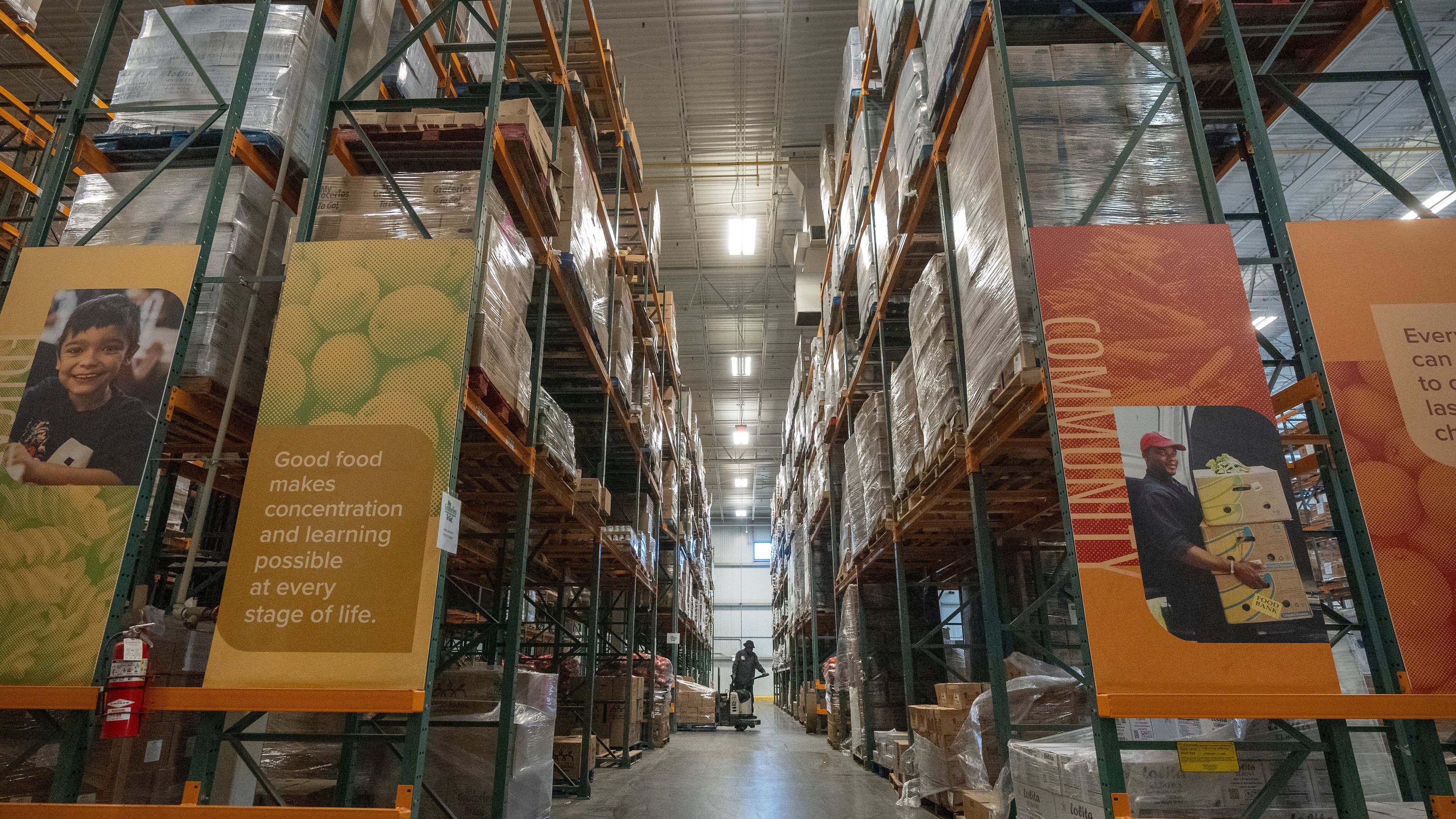 An employee moves pallets of food at a warehouse of the Capital Area Food Bank, Thursday, Nov. 6, 2025, in Washington. (AP Photo/Mark Schiefelbein)