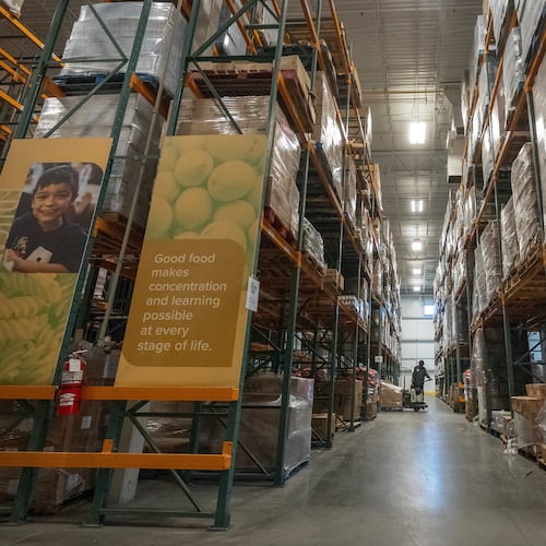 An employee moves pallets of food at a warehouse of the Capital Area Food Bank, Thursday, Nov. 6, 2025, in Washington. (AP Photo/Mark Schiefelbein)