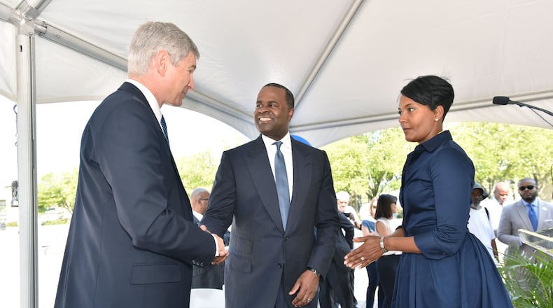 AUGUST 18, 2016 — Georgia State University President Mark Becker (left) and Atlanta Mayor Kasim Reed shake hands as Atlanta City Councilwoman Keisha Lance Bottoms (right) looks on following an announcement on Aug. 18, 2016, that a deal had been reached for Georgia State and its development partners to purchase Turner Field, the 20-year-old former Olympic stadium and former home of the Atlanta Braves. Councilwoman Bottoms is also director of the Atlanta Fulton County Recreation Authority. The Rec Authority and the Braves are fighting over money now that the team has left Atlanta for Cobb County. (Photo: Hyosub Shin/ hshin@ajc.com)