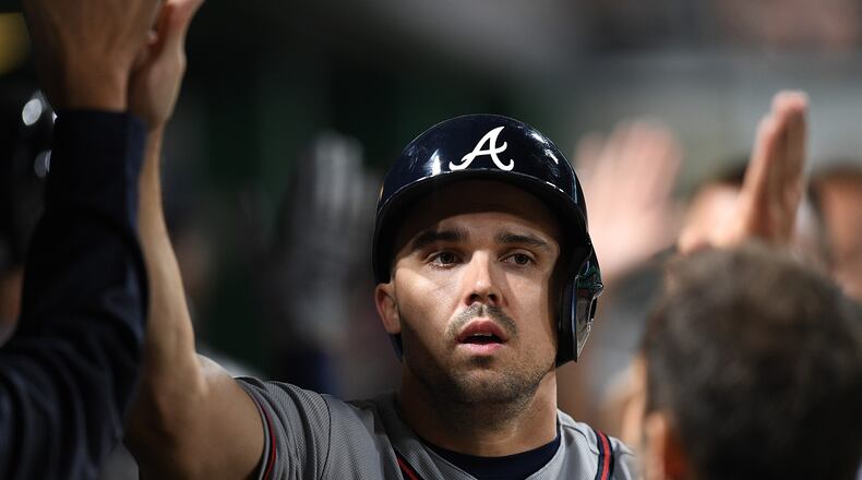 Adam Duvall of the Atlanta Braves is greeted by teammates in the dugout after coming around to score on an sacrifice fly ball by Freddie Freeman in the eighth inning during the game against the Pittsburgh Pirates at PNC Park on August 22, 2018 in Pittsburgh, Pennsylvania. (Photo by Justin Berl/Getty Images)