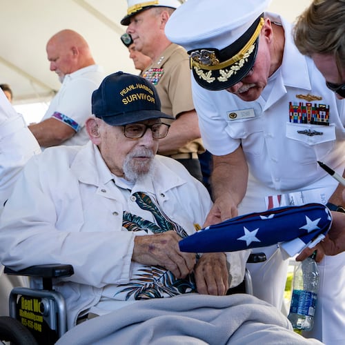FILE - An attendee asks Pearl Harbor survivor Ira "Ike" Schab, 103, to sign an U.S. flag during the 82nd Pearl Harbor Remembrance Day ceremony on Thursday, Dec. 7, 2023, at Pearl Harbor in Honolulu, Hawaii. (AP Photo/Mengshin Lin, File)