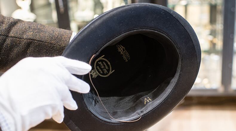 A man holds a top hat with the initials "AH" from the J A Seidl hat manufacturer on November 20,  in Grasbrunn, Germany, prior to an auction of personal belongings from German dictator Adolf Hitler and other notorious World War II Nazi leaders. The Nazi leader's top hat sold for 50,000 euros ($55,310), according to the Hermann Historica auction house website, while items of clothing belonging to his partner Eva Braun each sold for thousands.