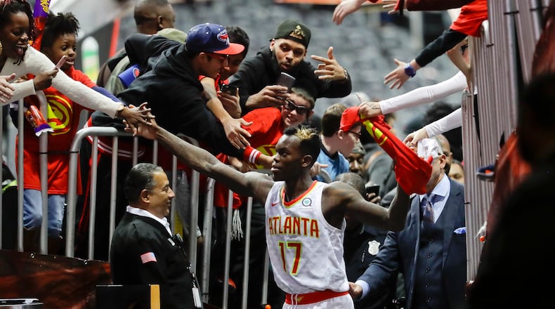 Atlanta Hawks guard Dennis Schroder (17) is mobbed by fans as he leaves the court following their 102-99 win over the San Antonio Spurs in an NBA basketball game Monday, Jan. 15, 2018, in Atlanta. (AP Photo/John Bazemore)