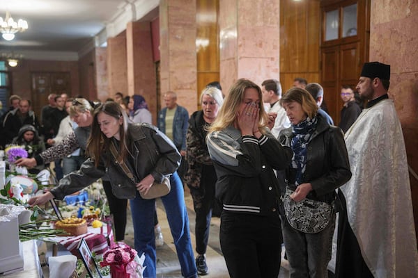 A woman cries during a funeral ceremony for Tamara Martyniuk, 8, Stanislav Martyniuk, 12, and Roman Martyniuk, 17, killed in a Russian strike on Sunday, in Korostyshiv, Zhytomyr region, Ukraine, Wednesday, May 28, 2025. (AP Photo/Evgeniy Maloletka)