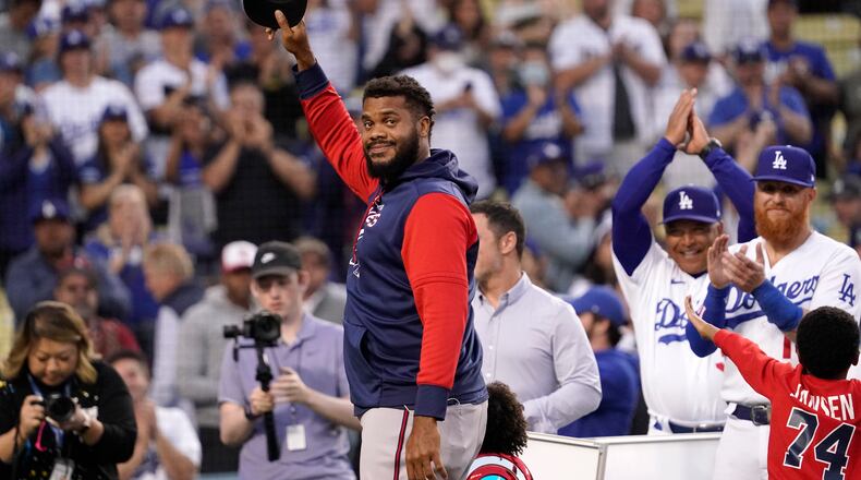 Braves relief pitcher and former Dodger Kenley Jansen, left, acknowledges the crowd while being honored with gifts frim his former teammates Los Angeles Dodgers manager Dave Roberts, third from right, and third baseman Justin Turner, second from right, prior to a baseball game Monday, April 18, 2022, in Los Angeles. (AP Photo/Mark J. Terrill)