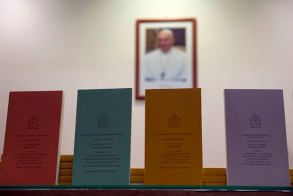 FILE - Copies of the post-synodal apostolic encyclical 'Amoris Laetitia' (The Joy of Love) document, by Pope Francis, are on display prior to the start of a press conference, at the Vatican, Friday, April 8, 2016. "Footnote 351; "I want to remind priests that the confessional must not be a torture chamber, but rather an encounter with the Lord's mercy. I would also point out that the Eucharist is not a prize for the perfect, but a powerful medicine and nourishment for the weak." (AP Photo/Andrew Medichini, File)