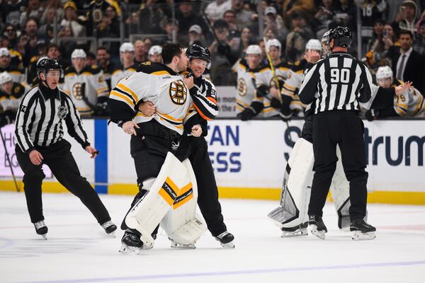 Boston Bruins goaltender Jeremy Swayman, left, is held back from fighting Los Angeles Kings goaltender Darcy Kuemper during the second period of an NHL hockey game Sunday, March 23, 2025, in Los Angeles. (AP Photo/William Liang)