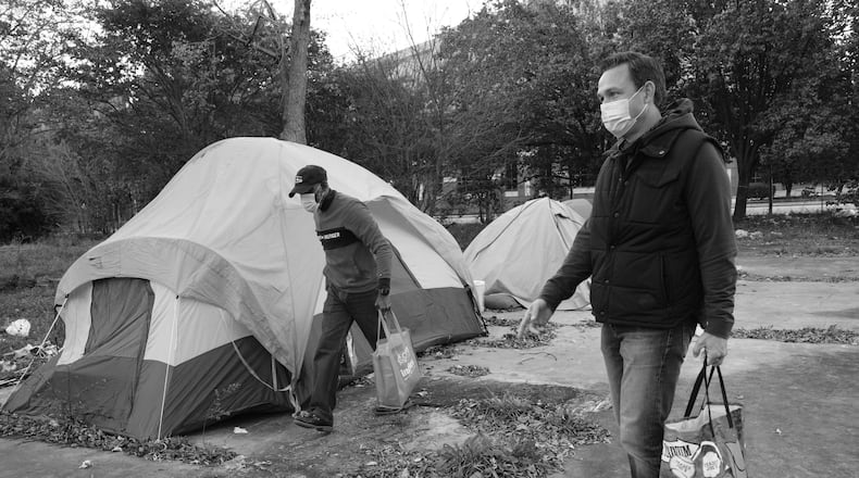Torrance Patrick (left) and Alva Jones hand out sandwiches at a homeless encampment in metro Atlanta. (Courtesy of Torrance Patrick)