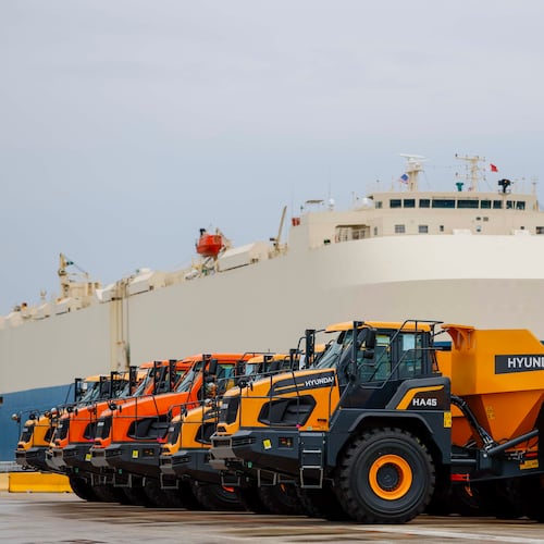 Dump trucks are parked as a ship prepares to depart the Georgia Port Authority in Brunswick, Ga., on Wednesday, Jan. 14, 2026. The GPA has invested in import-export facilities at its Brunswick terminal for heavy equipment manufacturers, including roll-in and roll-out, and a roofed facility for final assembly. (Miguel Martinez/AJC)