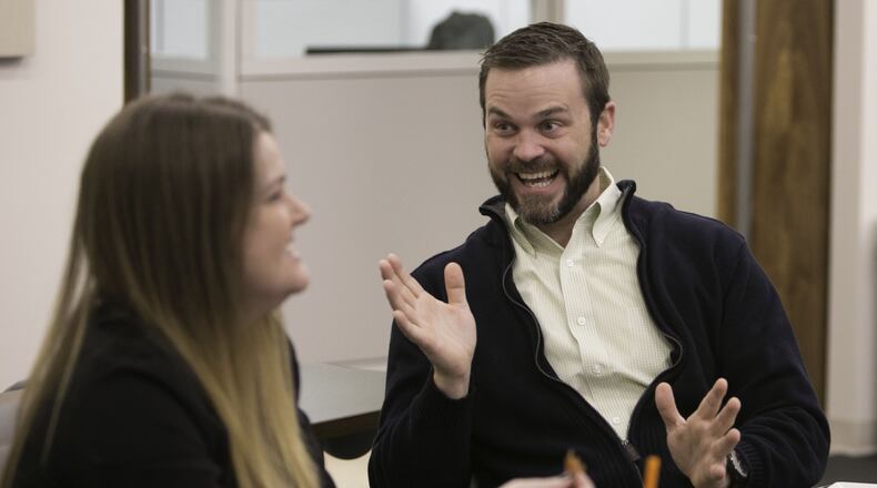 Kasie Grant (left) & Dave Davis enjoy a lively conversation as they share the breakfast provided at Baker Audio Visual in Norcross. The company has been voted the No 1 Top small workplace in the Atlanta area. (Photo by Phil Skinner)