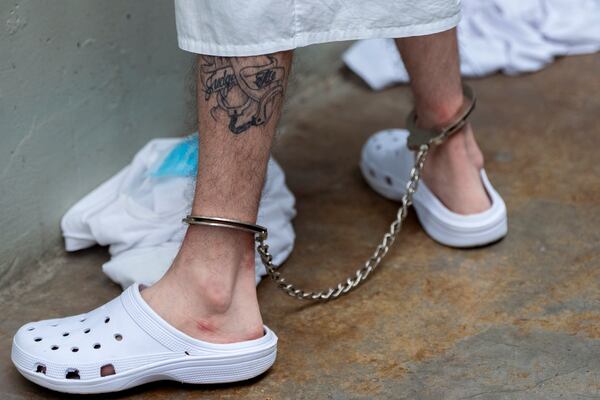 A prisoner with a tattoo with leg irons on stands as Homeland Security Secretary Kristi Noem tours the Terrorist Confinement Center in Tecoluca, El Salvador, Wednesday, March 26, 2025. (AP Photo/Alex Brandon)