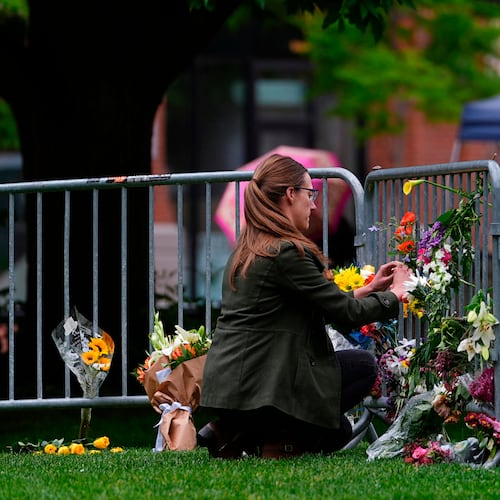 FILE - A woman places a bouquet of flowers at a makeshift memorial for victims of an attack outside of the Boulder County, Colo., courthouse Tuesday, June 3, 2025, in Boulder, Colo. (AP Photo/David Zalubowski, File)