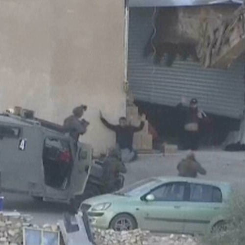 This image taken from video by Palestine TV shows two Palestinian men kneeling on the ground to Israeli forces shortly before they were shot dead during a military operation in Jenin, West Bank, on Thursday, Nov. 27, 2025. (Palestine TV via AP)