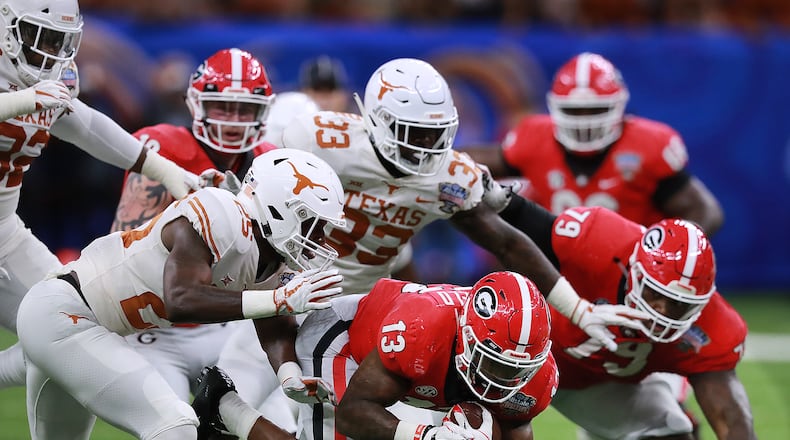 Jan. 01, 2019 New Orleans: Texas defenders bring down Georgia tailback Elijah Holyfield for short yardage during the first half in the Allstate Sugar Bowl at Mercedes-Benz Superdome on Tuesday, Jan. 1, 2019, in New Orleans. Curtis Compton/ccompton@ajc.com