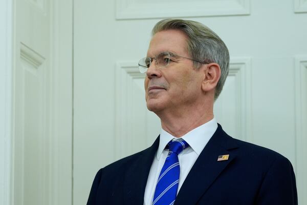 Treasury Secretary Scott Bessent listens as President Donald Trump speaks with reporters as he participates in a ceremonial swearing in of Paul Atkins as chairman of the Securities and Exchange Commission, in the Oval Office of the White House, Tuesday, April 22, 2025, in Washington. (AP Photo/Alex Brandon)
