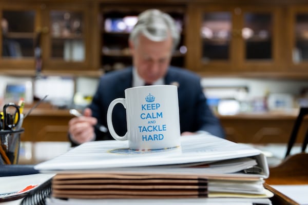Outgoing FBI Director Christopher Wray works in his office at the J. Edgar Hoover Building in Washington, D.C. on Sunday, Jan. 12, 2025. His coffee mug says “Keep Calm and Tackle Hard.” Arvin Temkar/AJC