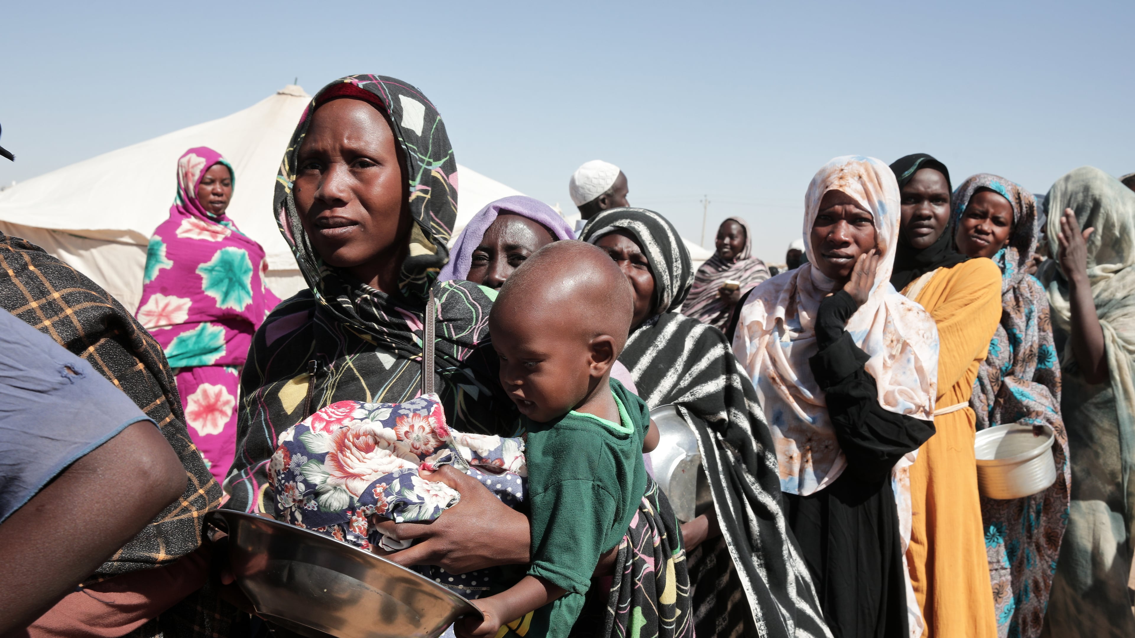 FILE - Women displaced from El-Fasher stand in line to receive food aid at the newly established El-Afadh camp in Al Dabbah, in Sudan's Northern State, Nov. 16, 2025. (AP Photo/Marwan Ali, File)