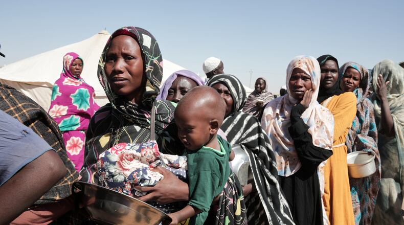 FILE - Women displaced from El-Fasher stand in line to receive food aid at the newly established El-Afadh camp in Al Dabbah, in Sudan's Northern State, Nov. 16, 2025. (AP Photo/Marwan Ali, File)