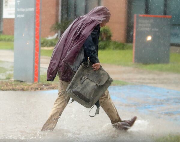 A man walks through high water during a downpour on Thursday, March 27, 2025, in Edinburg, Texas. (Joel Martinez /The Monitor via AP)