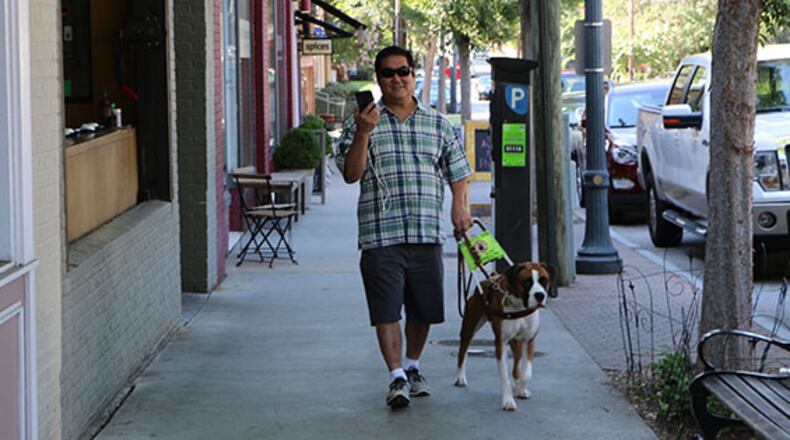 Foresight Augmented Reality co-founder, David Furukawa, demonstates his company’s app that, when paired with its Bluetooth beacon, can guide visually impaired people to, among other things, specific rooms, restrooms and elevators, along with descriptive information of entrances, exits, and hazard warnings. Sixty-five beacons have been recently installed throughout Decatur’s downtown. Courtesy of Foresight Augmented Reality