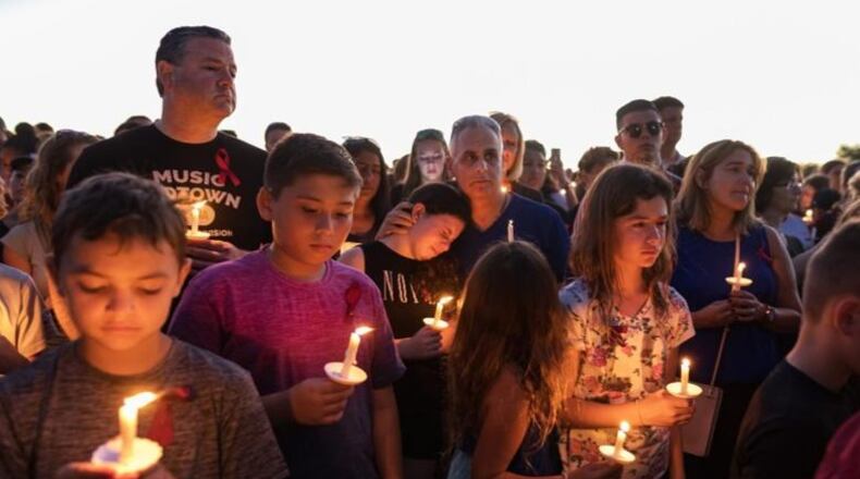 People attend a candlelit memorial service Thursay night for the victims of the shooting at Marjory Stoneman Douglas High School that killed 17 people.