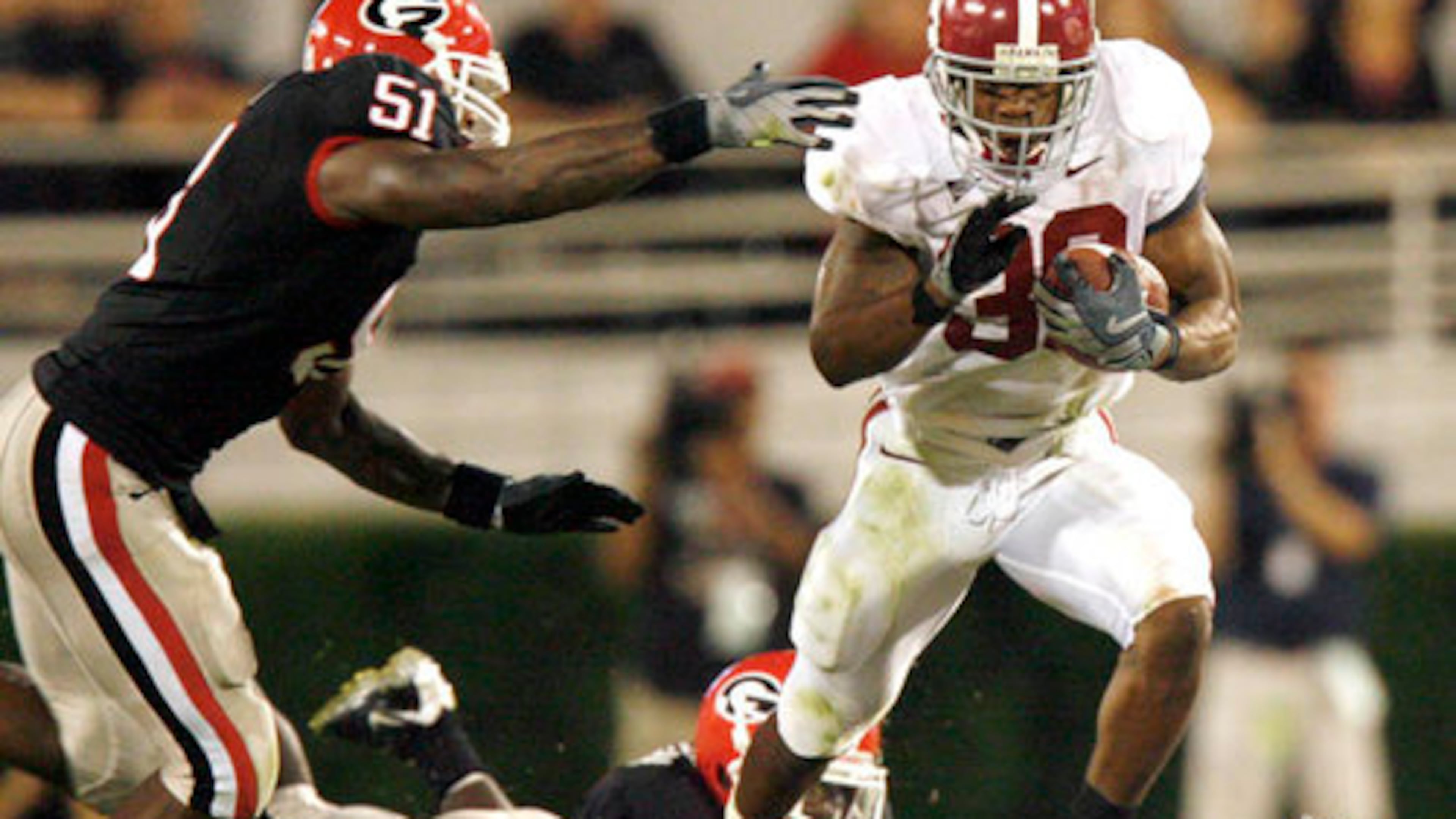 Alabama running back Glen Coffee runs through the gap between Georgia linebackers Akeem Dent (left) and Rennie Curran on Saturday, Sept. 27, 2008, at Sanford Stadium in Athens. The Crimson Tide deflated the Bulldogs, and the crowd, by racing to a 31-0 halftime lead before winning 41-30. (Jason Getz/AJC 2008)