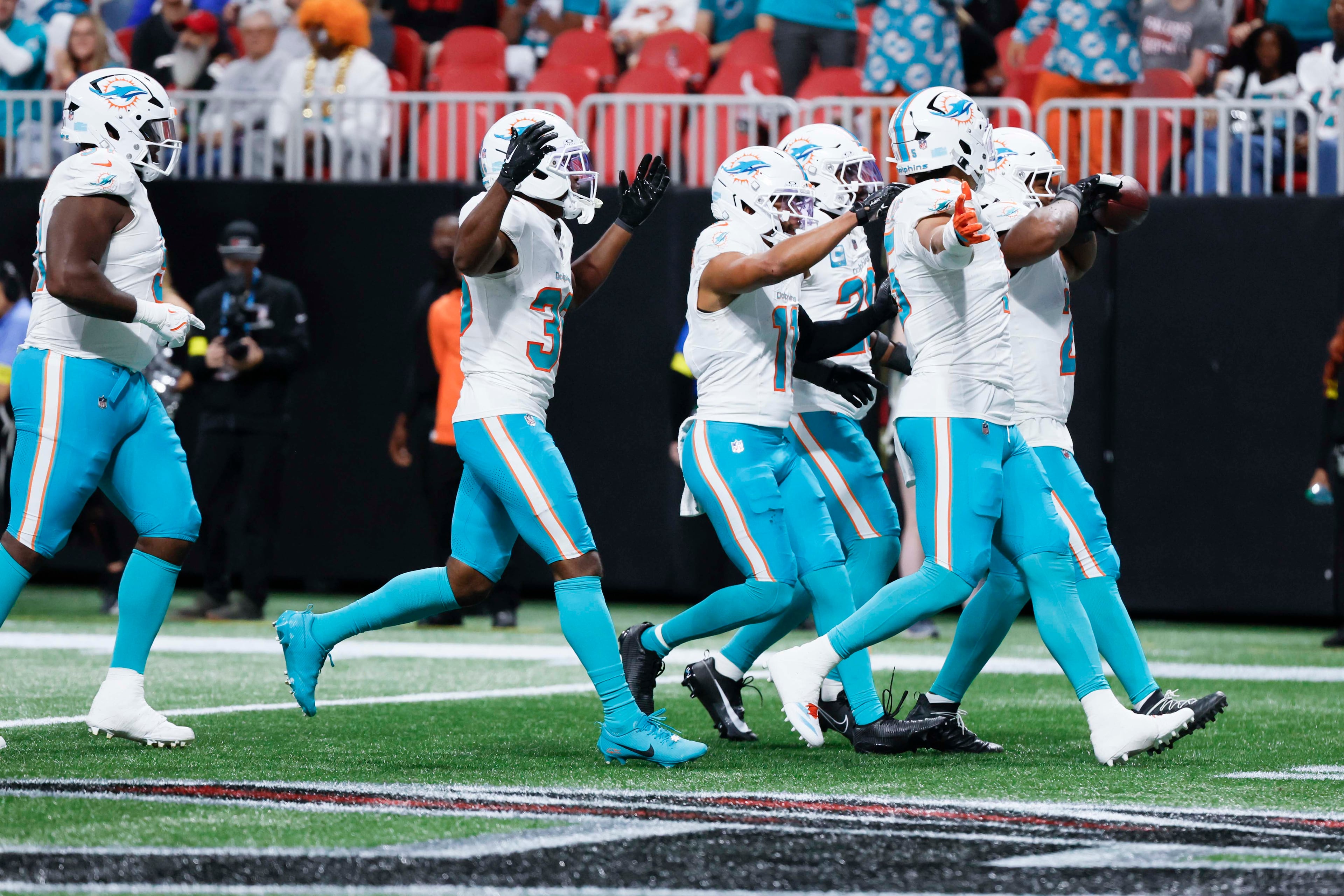 Miami Dolphins players celebrate after recovering a fumble during the second half of an NFL football game against the Atlanta Falcons at Mercedes-Benz Stadium in Atlanta on Sunday, Oct. 26, 2025. (Miguel Martinez/AJC)