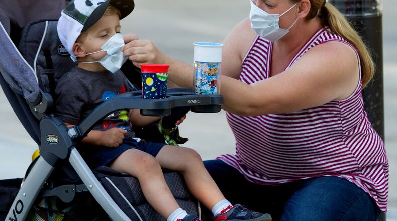 Marlie Arnold helps her son Lucas with his mask before entering the Atlanta zoo Saturday, May 16, 2020. STEVE SCHAEFER FOR THE ATLANTA JOURNAL-CONSTITUTION