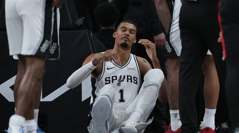 San Antonio Spurs forward Victor Wembanyama (1) sits on the court after a hard fall during the first half in Game 2 of a first-round NBA playoffs basketball series against the Portland Trail Blazers in San Antonio, Tuesday, April 21, 2026. (AP Photo/Eric Gay)