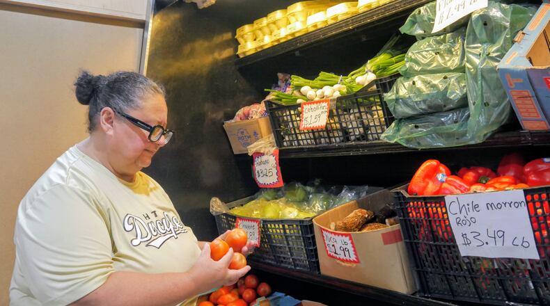 Ada Torres holds tomatoes while shopping for produce, Thursday, July 2, 2026, in Cleveland, Texas, about 45 miles northeast of Houston. (Sandy Guatibonza/La Esquina TX via AP)