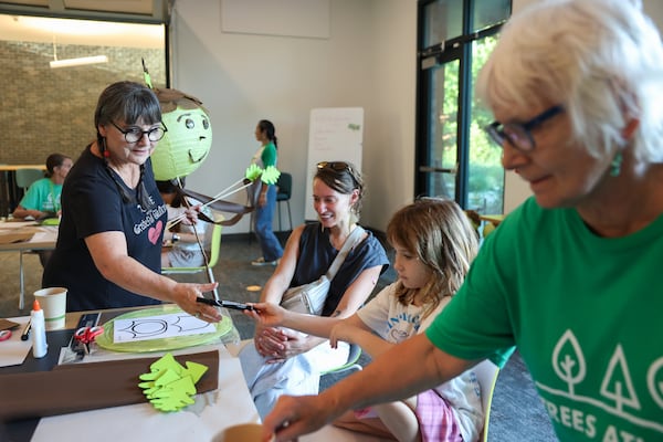 Atlanta Beltline Lantern Parade organizer Chantelle Rytter (left) shows volunteers Katie Timberlake and her 8-year-old daughter, Blake Cox, how to make acorn lantern puppets at Trees Atlanta on Thursday, Sept. 10, 2026. The acorn lanterns will march alongside the Oak King lantern in honor of Atlanta's tree canopy and Trees Atlanta. (Arvin Temkar/AJC)