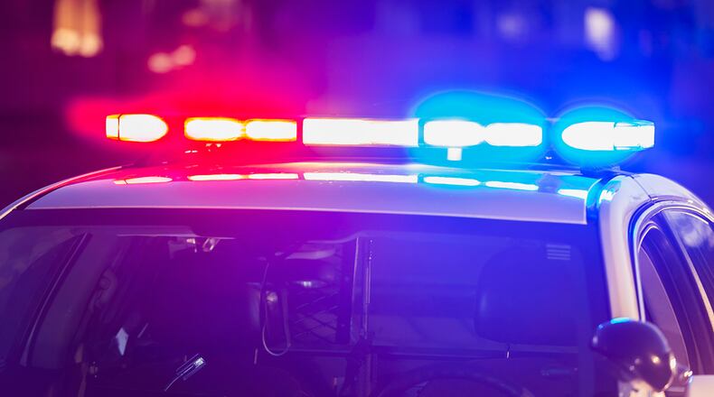 The roof of a police patrol car at night, with the blue and red lights flashing.
