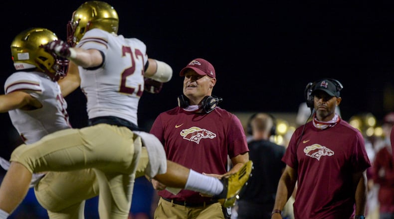 Brookwood head coach Philip Jones (middle) watches his player react to a touchdown in the second half of a September game against Walton. (Daniel Varnado/Special to the AJC)