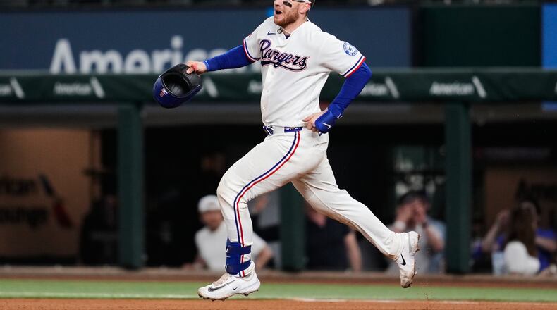 Texas Rangers' Danny Jansen celebrates his run-scoring single as he rounds first in the ninth inning of a baseball game against the Arizona Diamondbacks Wednesday, May 13, 2026, in Arlington, Texas. (AP Photo/Tony Gutierrez)