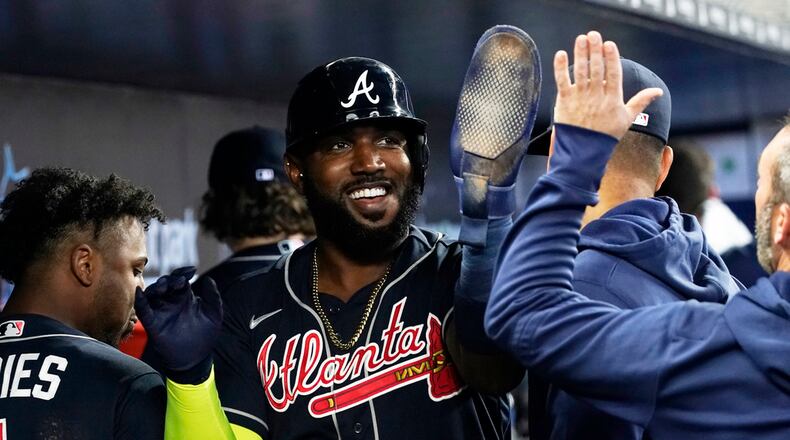 Atlanta Braves Marcell Ozuna (20) is congratulates by his teammates after scoring in the second inning of a baseball game against the Miami Marlins, Thursday, May 4, 2023, in Miami. (AP Photo/Marta Lavandier)