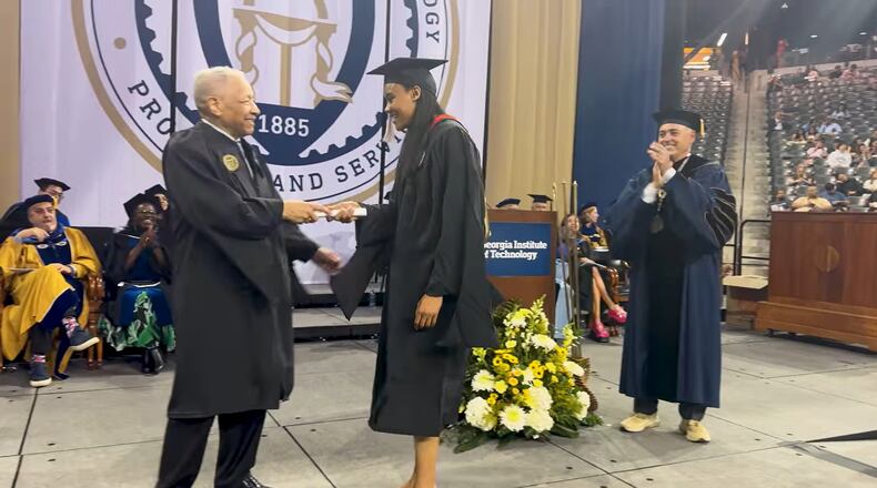 Ronald Yancey, who became the first Black person to graduate from Georgia Tech in 1965, hands a diploma to his granddaughter, Deanna Yancey, during a commencement ceremony on Friday, May 3, 2024. (Courtesy of Georgia Tech)