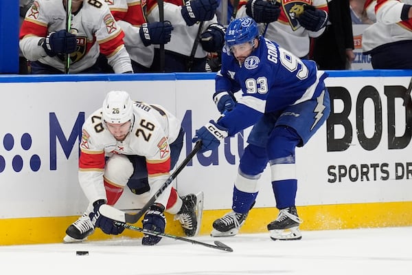 Tampa Bay Lightning center Gage Goncalves (93) takes down Florida Panthers defenseman Uvis Balinskis (26) during the first period in Game 5 of an NHL hockey Stanley Cup first-round playoff series, Wednesday, April 30, 2025, in Tampa, Fla. (AP Photo/Chris O'Meara)