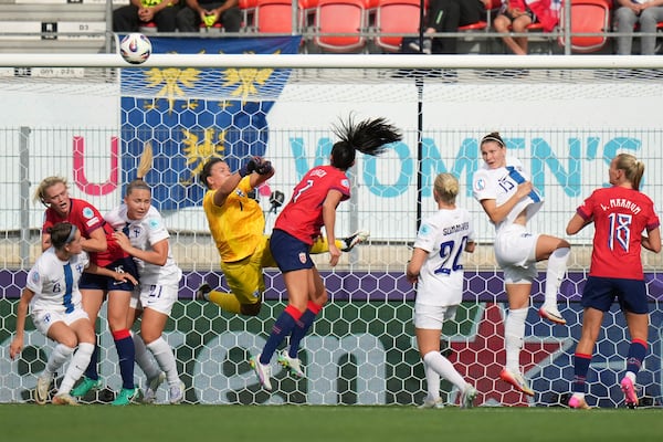 Norway's Ingrid Engen, center, tries to score past Finland goalkeeper Anna Koivunen during the Euro 2025, group A, soccer match between Norway and Finland at Stade de Tourbillon in Sion, Switzerland, Sunday, July 6, 2025. (AP Photo/Alessandra Tarantino)