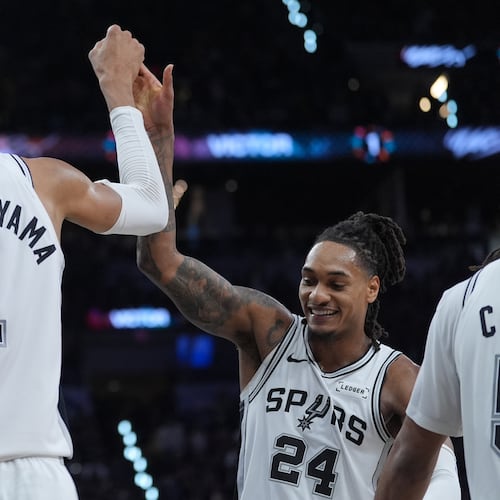 San Antonio Spurs forward/center Victor Wembanyama (1) reacts with guard/forward Devin Vassell (24) during the second half in Game 5 of a first-round NBA playoffs basketball series against the Portland Trail Blazers, in San Antonio, Tuesday, April 28, 2026. (AP Photo/Eric Gay)