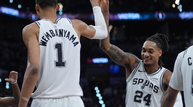 San Antonio Spurs forward/center Victor Wembanyama (1) reacts with guard/forward Devin Vassell (24) during the second half in Game 5 of a first-round NBA playoffs basketball series against the Portland Trail Blazers, in San Antonio, Tuesday, April 28, 2026. (AP Photo/Eric Gay)