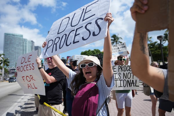 FILE - People hold signs and chant slogans during a protest against the Trump administration, Saturday, April 19, 2025, in Miami. (AP Photo/Lynne Sladky, File)