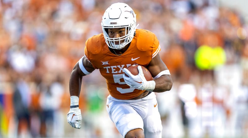 Texas running back Bijan Robinson carries against West Virginia during the first half of an NCAA college football game Saturday, Oct. 1, 2022, in Austin, Texas. (AP Photo/Stephen Spillman)