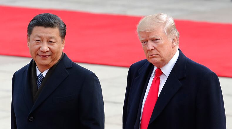 FILE - President Donald Trump, right, walks with Chinese President Xi Jinping during a welcome ceremony at the Great Hall of the people in Beijing, Nov. 9, 2017. (AP Photo/Andy Wong, File)