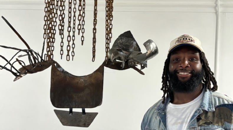 Georgia State senior linebacker Justin Abraham shows off his sculpture at the “Reimagining Success” exhibit in Decatur on Nov. 4, 2024. (Courtesy of Stan Awtrey)