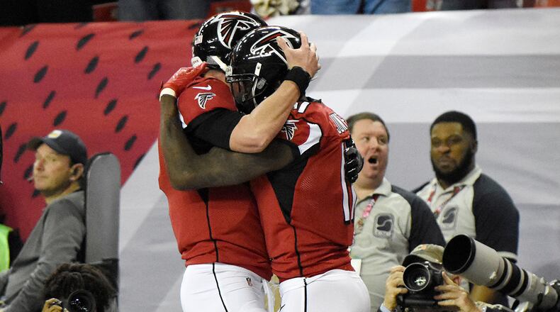 Falcons wide receiver Julio Jones (11) celebrates with quarterback Matt Ryan (2) after scoring a touchdown during the first half against the Saints Sunday, Jan. 1, 2017, at the Georgia Dome in Atlanta.