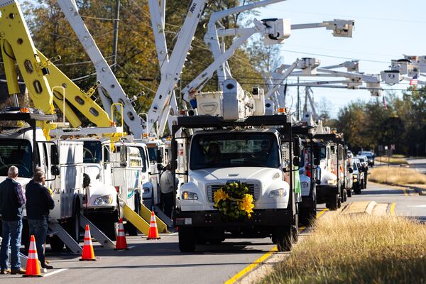 A bucket truck with flowers on the front was driven for a funeral procession in Griffin in honor of lineman Eric Weems on Thursday.