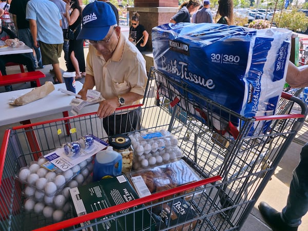 FILE - A customer checks his shopping receipts while waiting in line at the food court at Costco Wholesale store in Glendale, Calif., on Thursday, April 10, 2025. (AP Photo/Damian Dovarganes, File)
