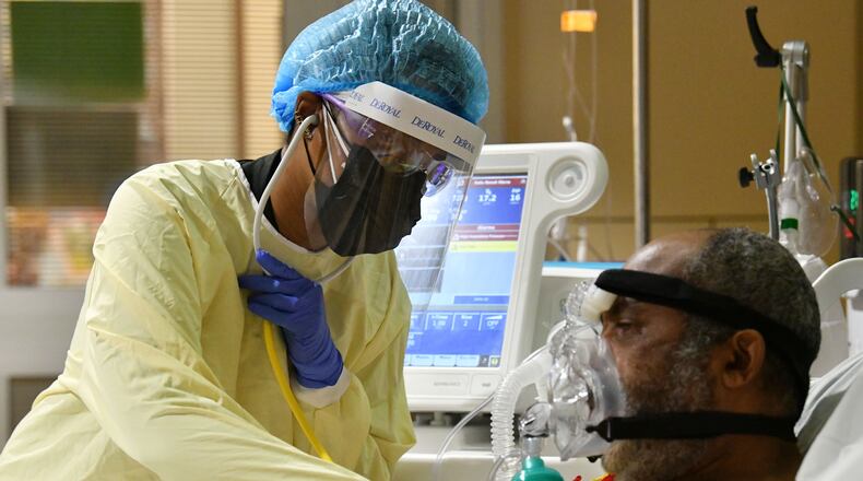 Dr. Erine Raybon-Rojas checks her patient infected with COVID-19 in Northeast Georgia Medical Center's (NGMC) Intensive Care Unit on Wednesday. For doctors working in hospitals, the last two weeks have been the most deadly in the COVID-19 battle. (Hyosub Shin / Hyosub.Shin@ajc.com)