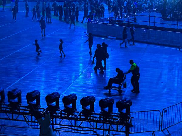 The stadium floor at Metallica featured his odd contrast: a man in a wheelchair juxtaposed with gleeful kids running around with headsets to protect their ears. (Rodney Ho/AJC)